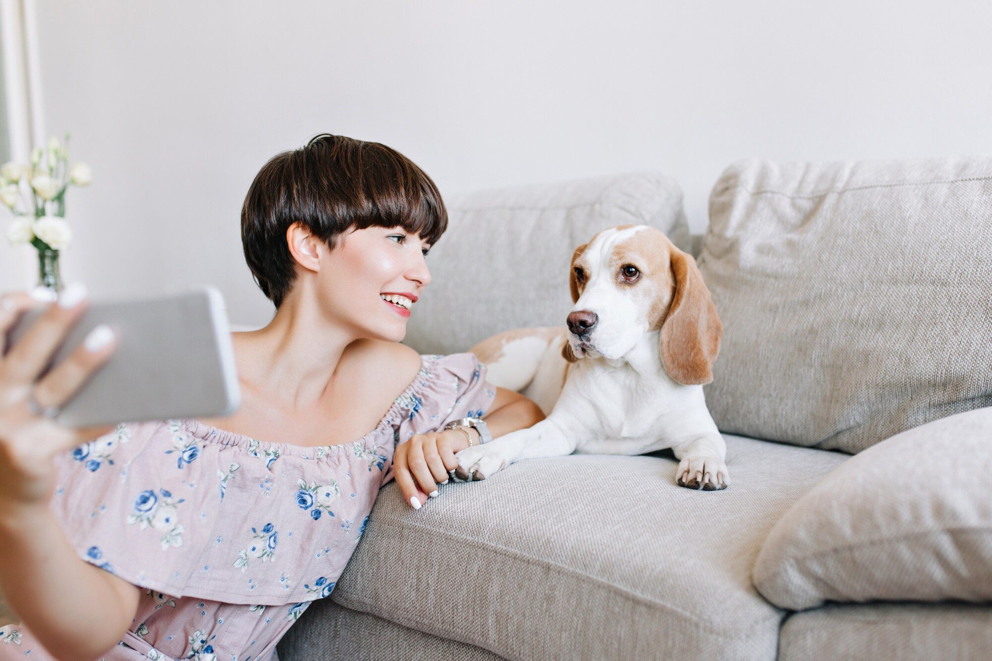 indoor-portrait-wonderful-dark-haired-girl-making-selfie-with-beagle-dog-lying-sofa_197531-4791
